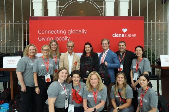 Ciena employees standing in front of a Ciena cares backdrop