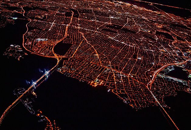 an aerial view of a city with a lot of buildings lit up at night