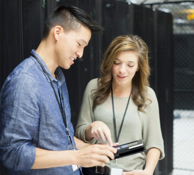 Two IT professionals working on a tablet