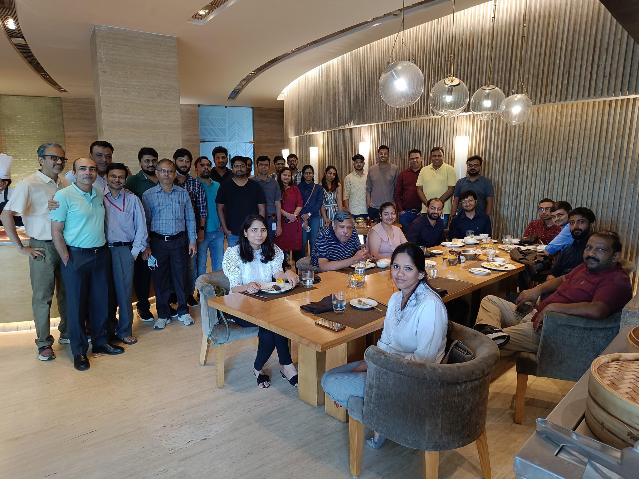 A group of men and women sitting around a table facing the camera.
