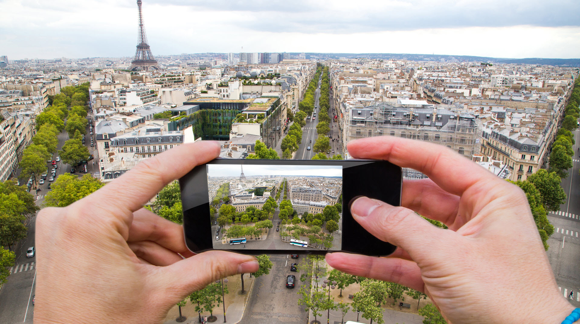Person taking a photo of Paris on a mobile phone
